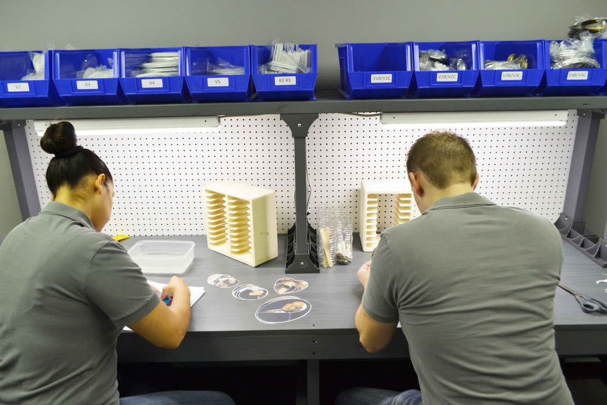 Two MemorialPics employees hand-assembling ceramic memorial photos