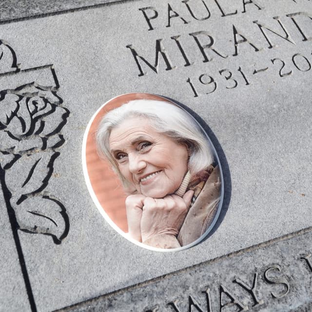 A ceramic memorial photo of a woman set into a headstone